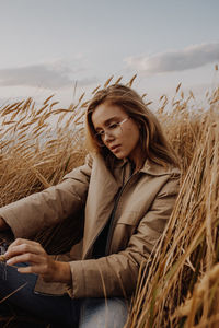 Young woman wearing mask on field against sky