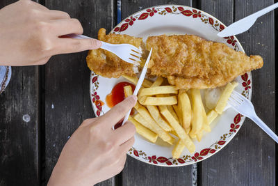 Cropped hands having food at table