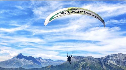 Person paragliding against sky