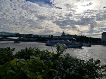 Bridge over river in city against sky