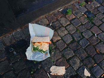 High angle view of fallen wrap sandwich on footpath in city