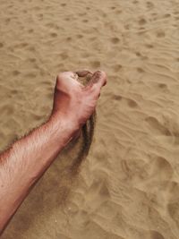 Midsection of man on sand at beach