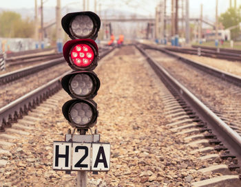 Small railway traffic light with red-light signal standing near the railway tracks