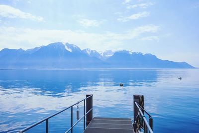 Scenic view of sea and mountains against sky