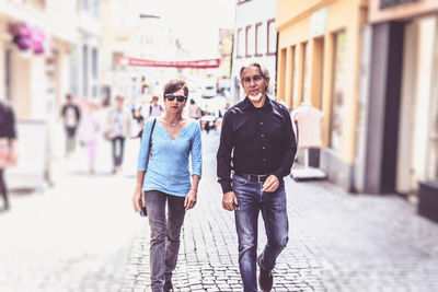 Full length portrait of young man walking on street in city