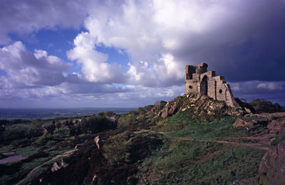 Mow cop castle on mountain against cloudy sky