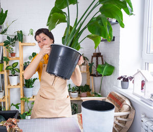 Portrait of woman holding potted plant