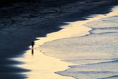 Shadow of person on sand at beach