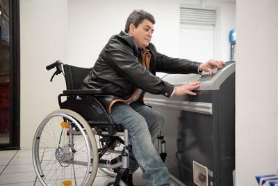 A disabled person in a wheelchair buys groceries