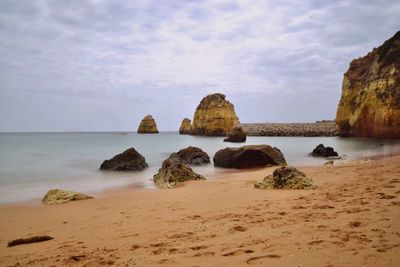 Rocks on beach against sky