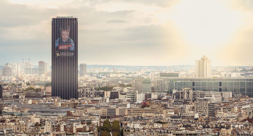 Buildings in city against cloudy sky