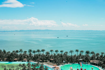 People swimming in sea against blue sky