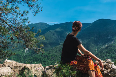 Woman looking at mountains against sky