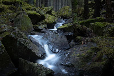 Stream flowing through rocks in nordic forest