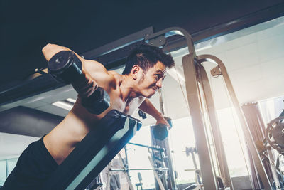 Shirtless man exercising at gym