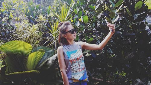 Young woman standing by plants