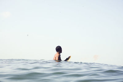 Full length of man swimming in sea against sky