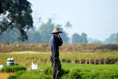 Side view of farmer standing on field