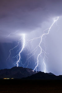 Lightning over silhouette mountains