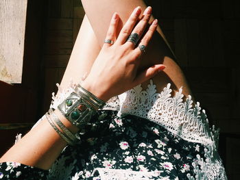 Midsection of woman wearing bangles and rings during sunny day