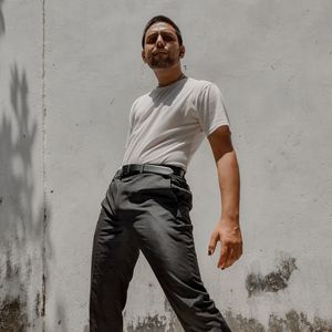 Portrait of young man standing against wall