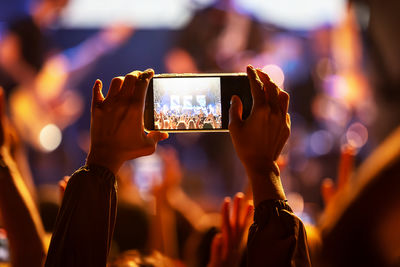 The audience records videos and takes photos with their smartphones during the concert