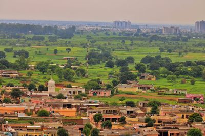 High angle view of trees and houses on field against sky