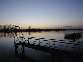 Scenic view of lake against clear sky during sunset