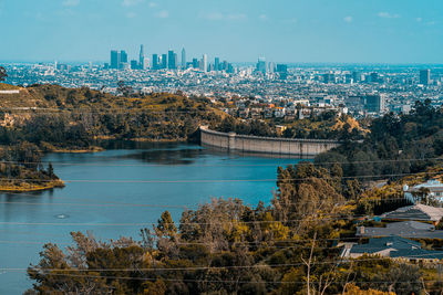 Scenic view of river by buildings against sky