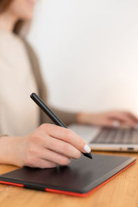 Midsection of woman using laptop on table