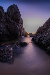 Rock formations in sea against sky