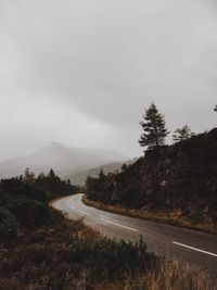 Road passing through landscape against sky