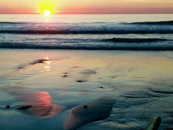 Scenic view of beach against sky during sunset