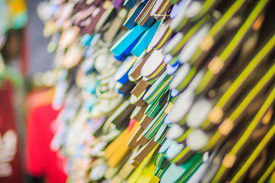 Low angle view of multi colored slippers hanging in market for sale