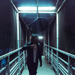 Man standing in illuminated underground walkway