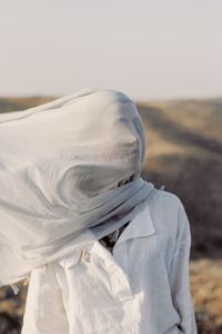 Midsection of woman standing on field against sky