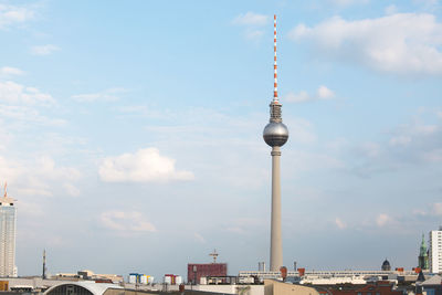 Low angle view of fernsehturm against cloudy sky