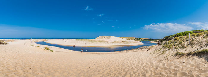 Panoramic view of beach against blue sky