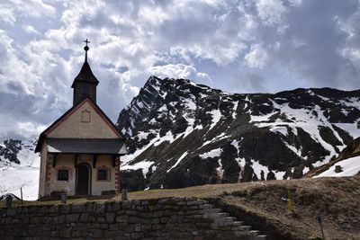 View of church by snowcapped mountain