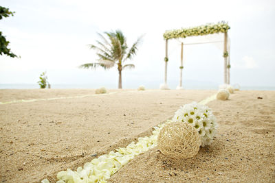 Close-up of decorations on beach against sky