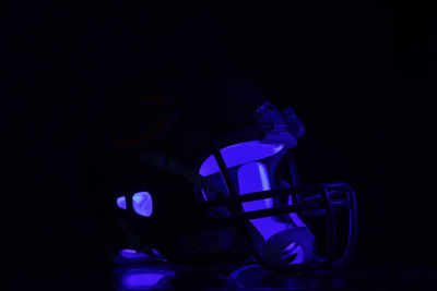 Close-up of illuminated lighting equipment against black background