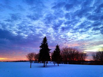 Snow covered landscape against cloudy sky