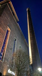 Low angle view of illuminated building against sky at night