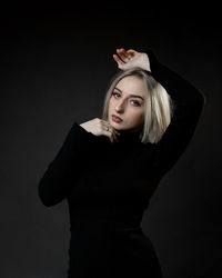 Portrait of a young woman over black background