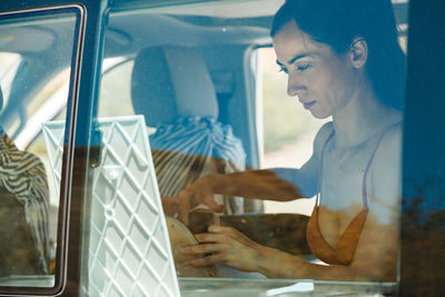 Midsection of woman seen through window