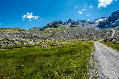 Scenic view of landscape and mountains against blue sky