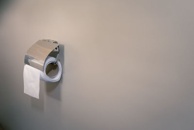 Close-up of tissue roll on wall at home