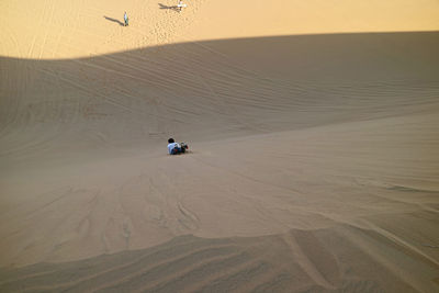High angle view of man sandboarding in desert