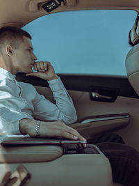 Boy using mobile phone while sitting in car