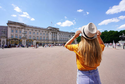 Rear view of young tourist woman visiting london, united kingdom